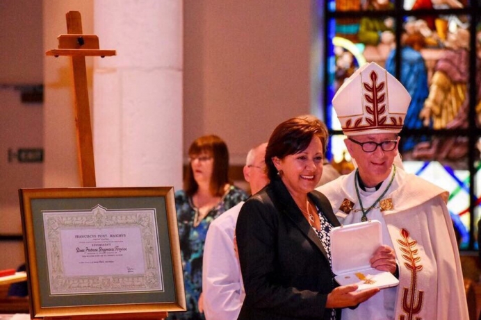 Andrea Krazeise, executive director of The Pregnancy Center of Sanford &amp; Oviedo, accepts a medal and a document signed and sealed by Pope Francis.