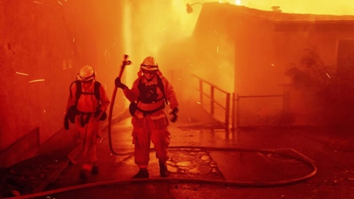 In this Thursday, Nov. 8, 2018 file photo, firefighters battle the Camp Fire as it tears through Paradise, Calif.