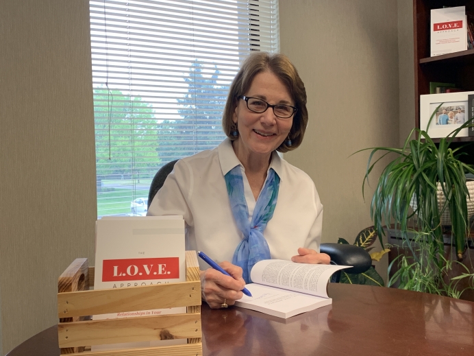 Peggy Hartshorn with her book The L.O.V.E. Approach
